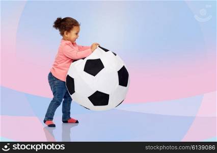 childhood, game, football and people concept - happy african american little baby girl playing with ball over pink and violet background