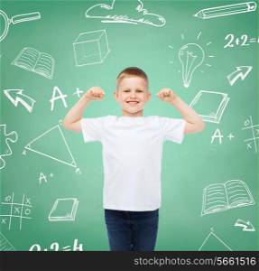 childhood, gesture, education, advertisement and people concept - smiling boy in white t-shirt with raised hands over green board with doodles background