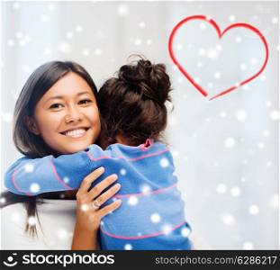 childhood, happiness, family and people concept - smiling little girl and mother hugging indoors