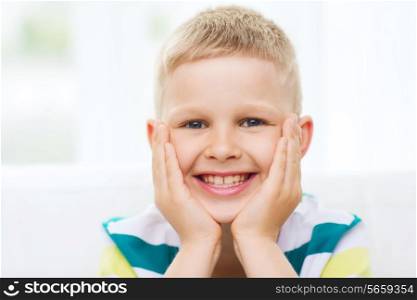 childhood, happiness, home and people concept - portrait of smiling little boy at home