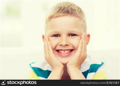 childhood, happiness, home and people concept - portrait of smiling little boy at home