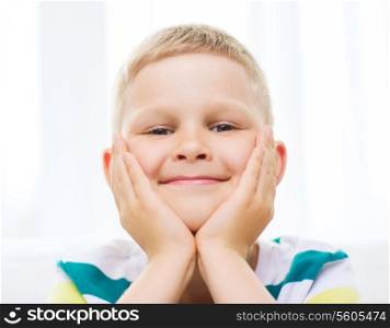 childhood, happiness, home and people concept - portrait of smiling little student boy at home