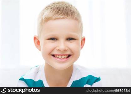childhood, happiness, home and people concept - portrait of smiling little student boy at home