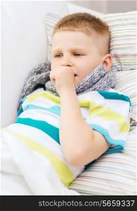 childhood, healthcare and medicine concept - ill boy with flu coughing at home