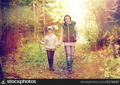 childhood, hiking and family concept - two happy kids walking along forest path. two happy kids walking along forest path