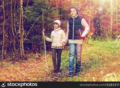 childhood, hiking and family concept - two happy kids walking along forest path. two happy kids walking along forest path
