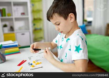 childhood, hobby and leisure concept - little boy playing with building kit at home. little boy playing with building kit at home