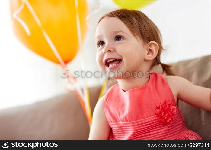 childhood, holidays, emotions and people concept - happy baby girl on birthday party at home. happy baby girl on birthday party at home