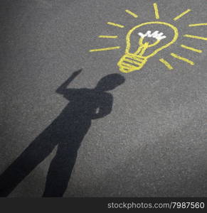 Childhood imagination and child creativity concept as the shadow of an inspired boy with a lightbulb chalk drawing on city asphalt as a symbol of inspiration and creative learning or back to school ideas.