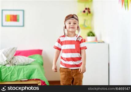 childhood, imagination and dream concept - happy little boy in pilot hat at home. happy little boy in pilot hat at home