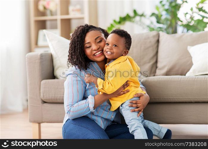 childhood, kids and people concept - happy african american mother with her baby son at home. happy african american mother with baby at home