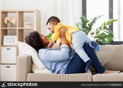 childhood, kids and people concept - happy african american mother with her baby son at home. happy african american mother with baby at home