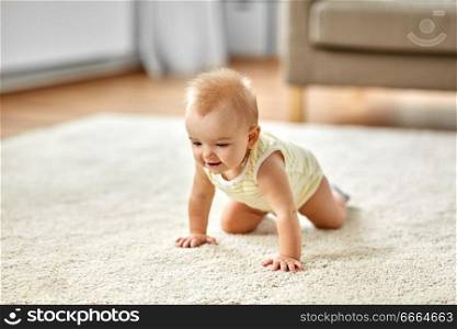 childhood, kids and people concept - lovely baby girl crawling on floor at home. lovely baby girl crawling on floor at home