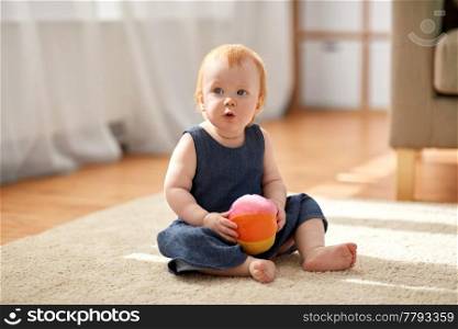 childhood, kids and people concept - lovely redhead baby girl with toy ball at home. lovely redhead baby girl with toy ball at home