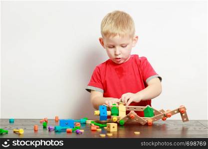 Childhood, kids imagination concept. Concentrated little boy playing with toys having fun. Little boy playing with toys having fun
