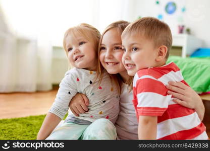 childhood, leisure and family concept - happy little kids hugging at home. happy little kids hugging at home