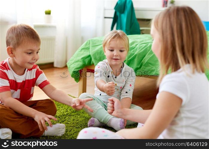 childhood, leisure and family concept - happy little kids playing rock-paper-scissors game at home. kids playing rock-paper-scissors game at home
