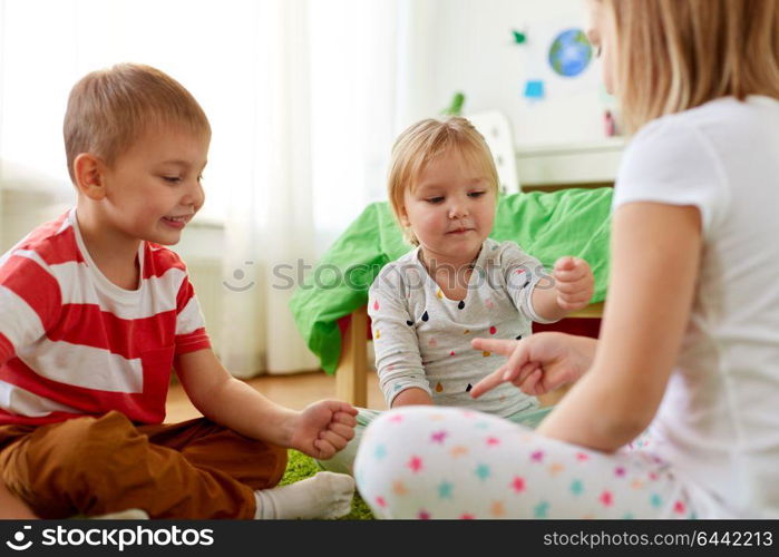 childhood, leisure and family concept - happy little kids playing rock-paper-scissors game at home. kids playing rock-paper-scissors game at home