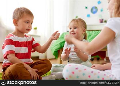 childhood, leisure and family concept - happy little kids playing rock-paper-scissors game at home. kids playing rock-paper-scissors game at home. kids playing rock-paper-scissors game at home