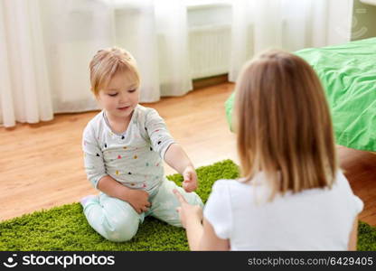 childhood, leisure and family concept - little girls playing rock-paper-scissors game at home. girls playing rock-paper-scissors game at home