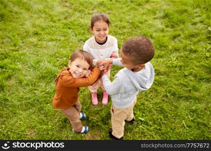 childhood, leisure and people concept - group of children playing game at park. group of children playing game at park