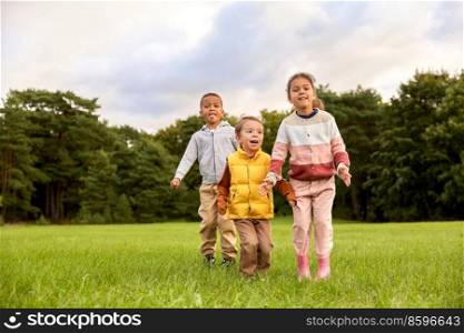 childhood, leisure and people concept - group of happy children playing and jumping at park. happy children playing and jumping at park