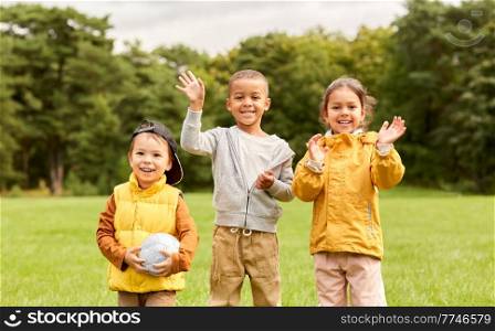 childhood, leisure and people concept - group of happy children with soccer ball at park. happy children with soccer ball at park