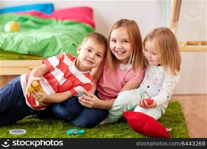childhood, leisure and people concept - group of kids with modelling clay or slimes at home. kids with modelling clay or slimes at home