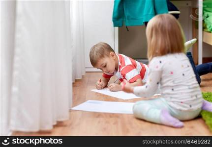 childhood, leisure and people concept - happy boy drawing at home. happy kids drawing at home