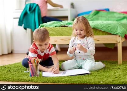 childhood, leisure and people concept - happy kids drawing at home. happy kids drawing at home