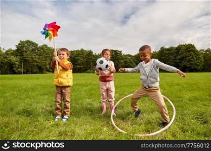 childhood, leisure and people concept - happy kids with toys having fun at park. happy children with toys playing at park