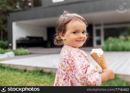 childhood, leisure and people concept - happy little baby girl eating ice cream. happy little baby girl eating ice cream