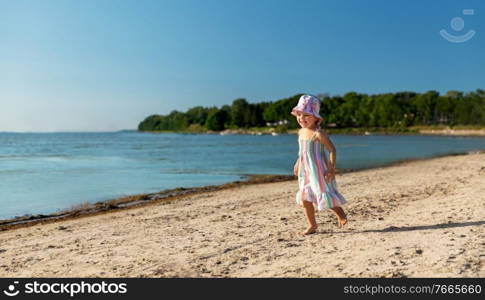 childhood, leisure and people concept - happy little baby girl running along summer beach. happy baby girl running on summer beach