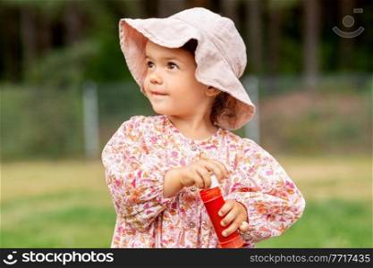 childhood, leisure and people concept - happy little baby girl with soap bubble blower in summer. happy baby girl with soap bubble blower in summer