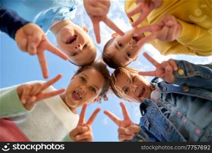 childhood, leisure and people concept - multiethnic group of happy children showing peace gesture under blue sky. group of happy children showing peace gesture