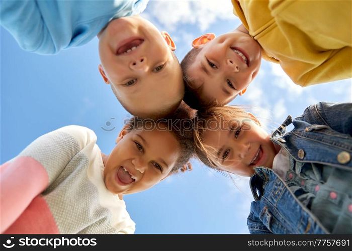 childhood, leisure and people concept - multiethnic group of happy children under blue sky. multiethnic group of happy children under blue sky