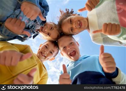 childhood, leisure and people concept - multiethnic group of happy kids showing thumbs up outdoors. happy children showing thumbs up outdoors