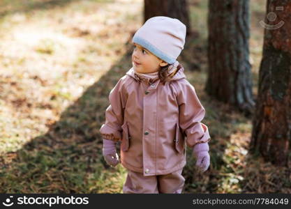 childhood, leisure and season concept - happy little baby girl walking in autumn park. happy little baby girl walking in autumn park