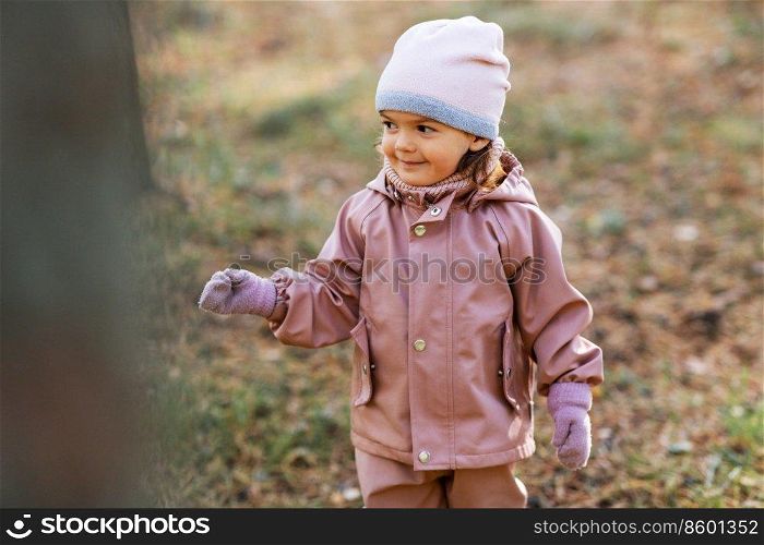 childhood, leisure and season concept - happy little baby girl walking in autumn park. happy little baby girl walking in autumn park