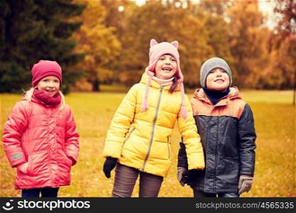 childhood, leisure, friendship and people concept - group of happy children in autumn park