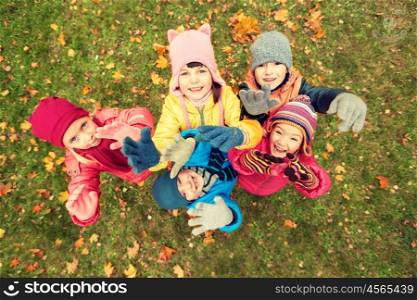 childhood, leisure, friendship and people concept - group of happy children waving hands in autumn park from top
