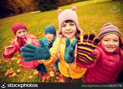 childhood, leisure, friendship and people concept - group of happy children waving hands in autumn park