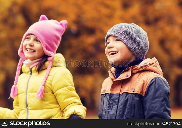 childhood, leisure, friendship and people concept - group of happy kids in autumn park