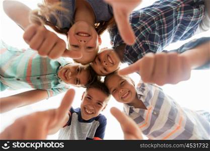 childhood, leisure, friendship and people concept - group of smiling happy children showing thumbs up in circle