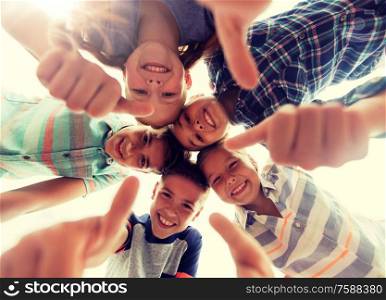 childhood, leisure, friendship and people concept - group of smiling happy children showing thumbs up in circle. happy children showing thumbs up in circle