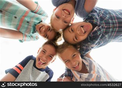 childhood, leisure, friendship and people concept - group of smiling happy children showing tongue in circle