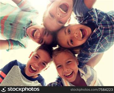 childhood, leisure, friendship and people concept - group of smiling happy laughing children faces in circle. group of happy children faces in circle