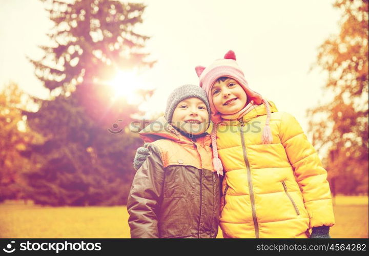 childhood, leisure, friendship and people concept - happy little girl and boy in autumn park