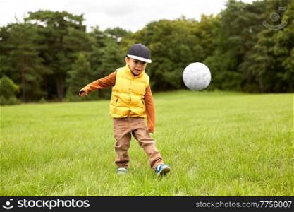 childhood, leisure games and people concept - little boy with soccer ball at summer park. little boy with soccer ball at park
