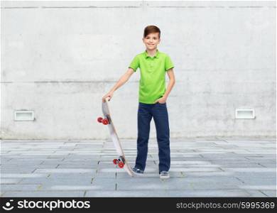 childhood, leisure, school and people concept - happy smiling boy with skateboard over urban street background
